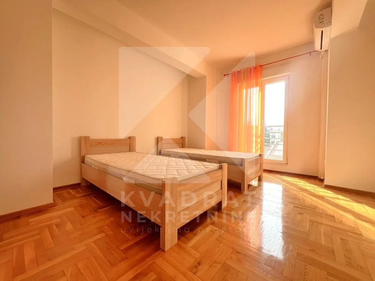 Bedroom with two wooden beds and access to the terrace.