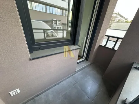 Manja terasa sa keramičkim pločicama i pogledom na okolne zgrade. - image 10
