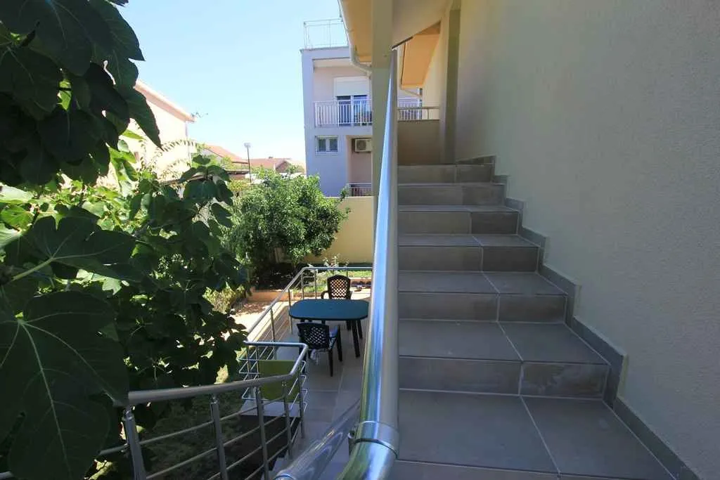 Vanjske stepenice koje vode na gornji sprat i pogled na mali popločani dio dvorišta.