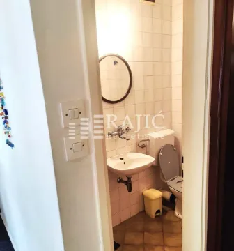 Small bathroom with a sink, toilet, and mirror. - image 7