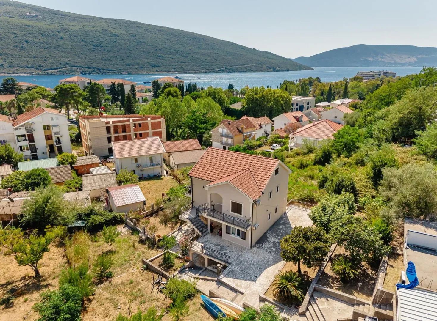 Pogled iz vazduha na kuću sa dvorištem i okolinom u blizini mora.