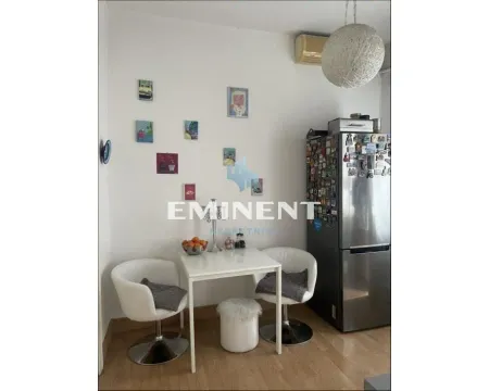 Small dining area with a table, chairs, and refrigerator. - image 6