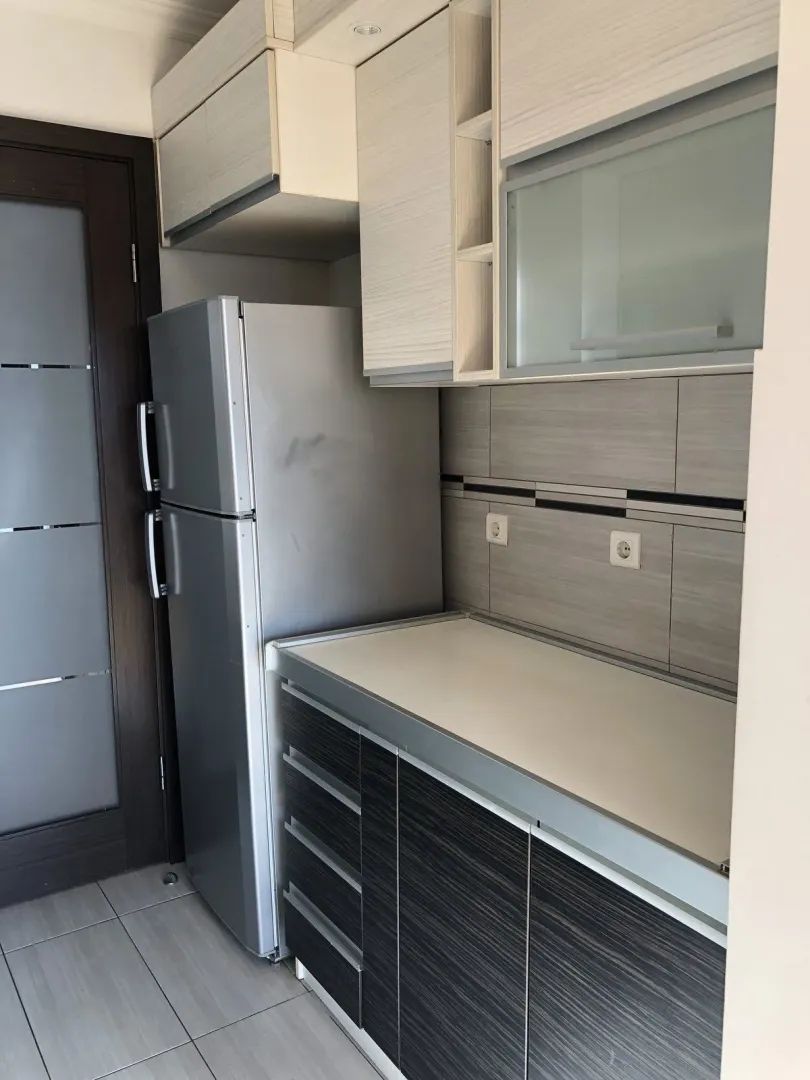 Modern kitchen cabinets with a refrigerator.