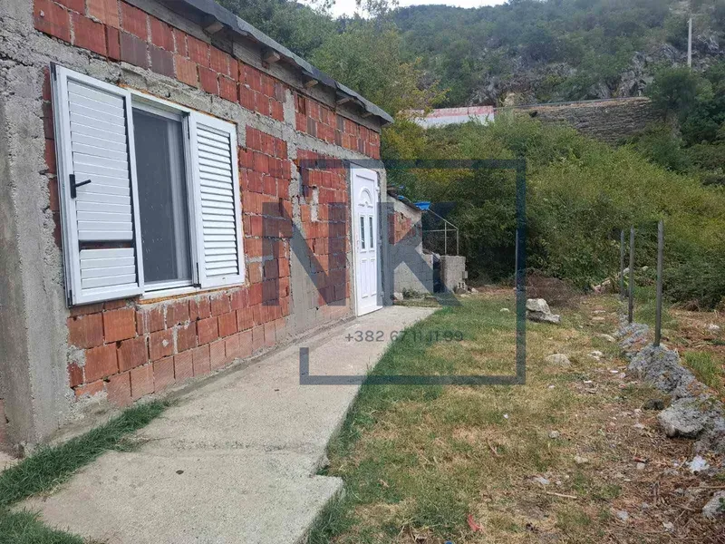 Spoljašnji izgled kuće sa dvorištem i prilazom.