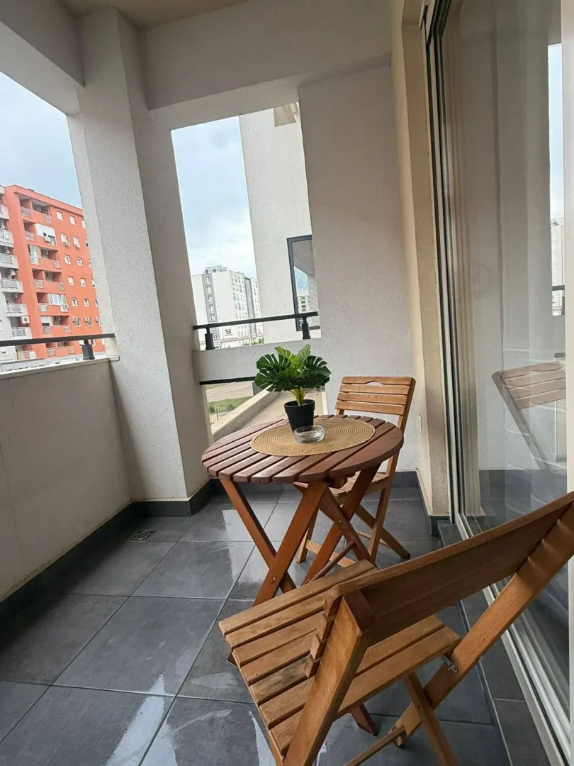 Furnished balcony with a wooden table and chairs.