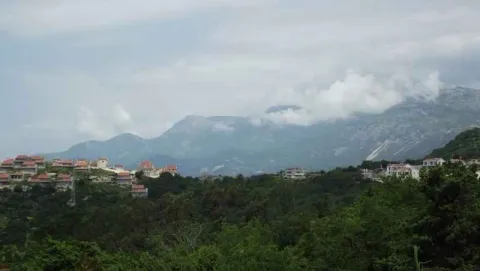 Pogled na planinski pejzaž i naselje sa zelenilom u prvom planu. - image 2