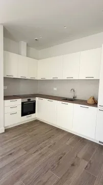 Moderna kuhinja sa bijelim elementima i drvenom radnom pločom. - image 2