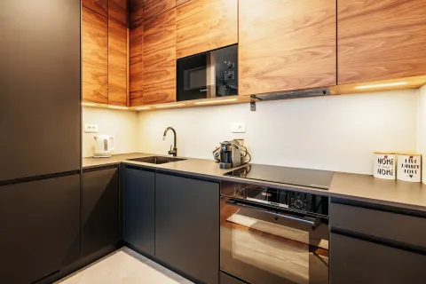 Modern kitchen with dark lower cabinets and wooden upper wall units. - image 6