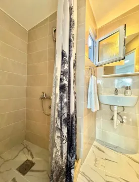 Small bathroom with a shower cabin and a sink. - image 6