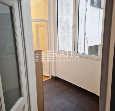 Enclosed balcony with dark floor tiles and a view of the neighboring building. - image 9