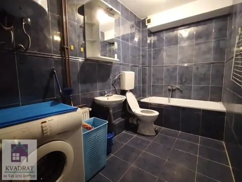 Blue tiled bathroom featuring a bathtub, washbasin, toilet, and washing machine. - image 9