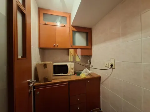 Small kitchen with wooden cabinets and a microwave. - image 8