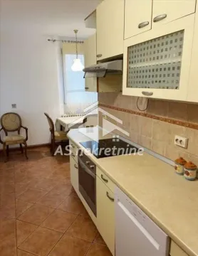 Kitchen equipped with cabinetry, built-in cooktop and oven, and a dining table in the background. - image 11