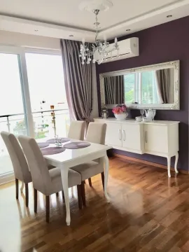 Svijetla trpezarija sa bijelim stolom, stolica i elegantnom komodom pored ljubičastog zida. - image 5
