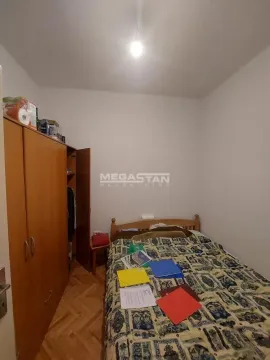 Small bedroom with a bed and a wooden wardrobe. - image 3