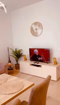 Svijetla dnevna soba sa TV komodom i ukrasnim detaljima. - image 4