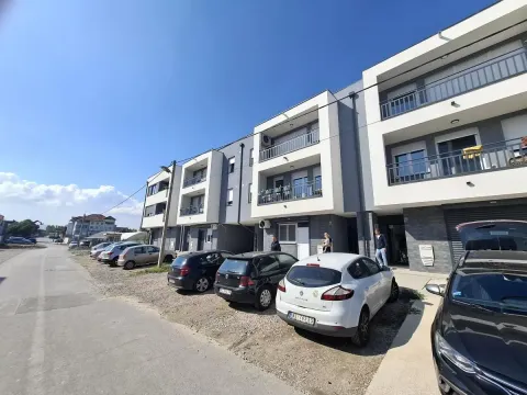 Pogled na spoljašnjost moderne stambene zgrade sa parkingom ispred. - image 11