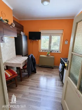 Kuhinja sa trpezarijskim stolom i narandžastim zidovima. - image 4