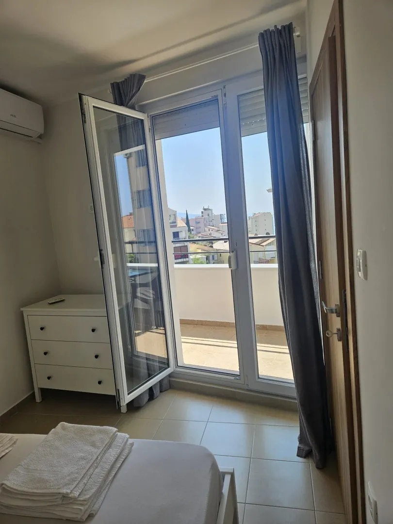 Bedroom with balcony access and city view.