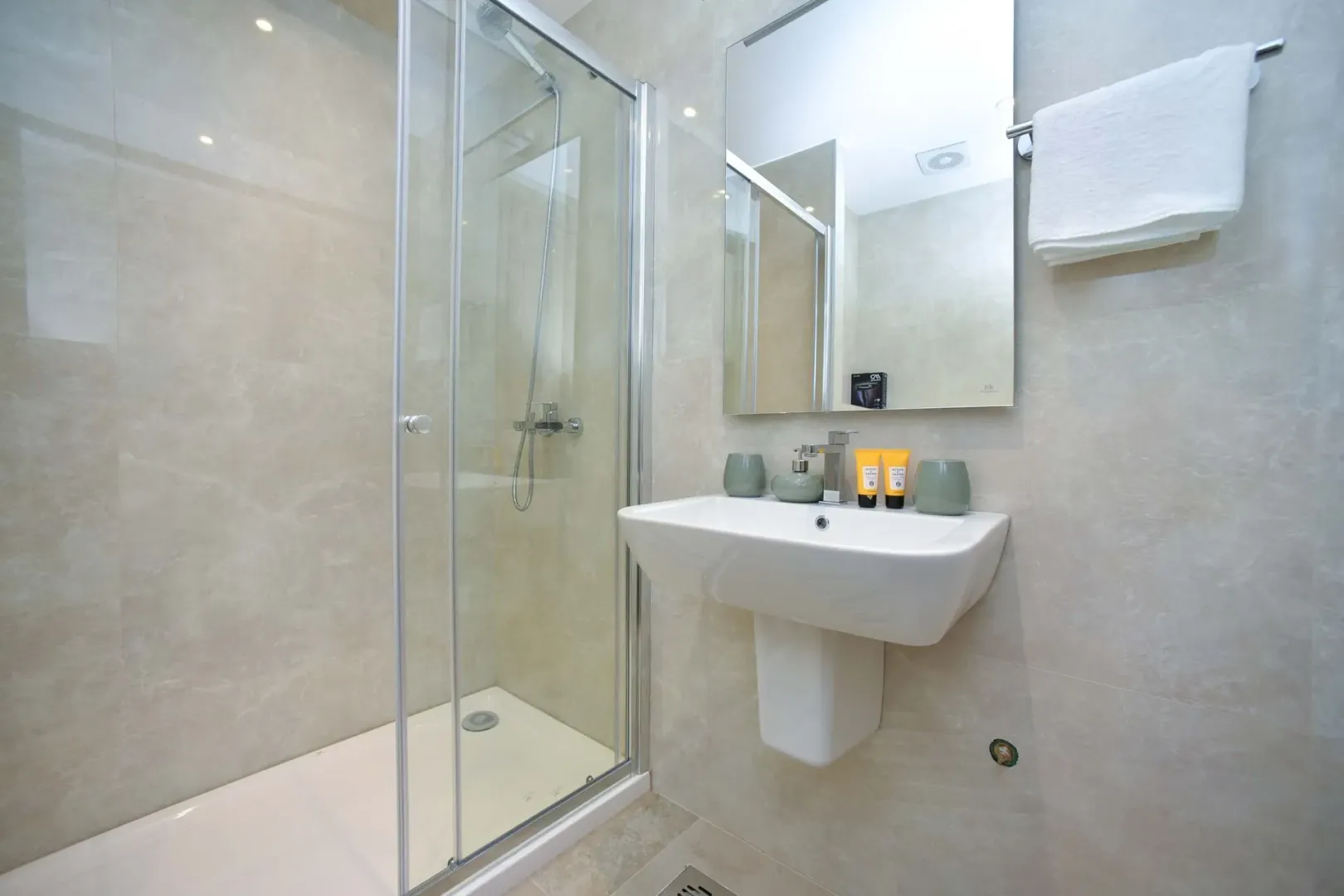 Modernly equipped bathroom with a shower cabin and a washbasin.