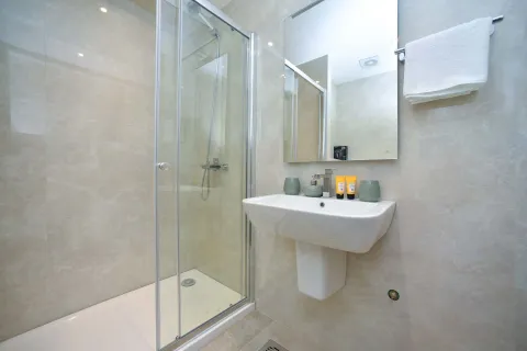 Modernly equipped bathroom with a shower cabin and a washbasin. - image 6