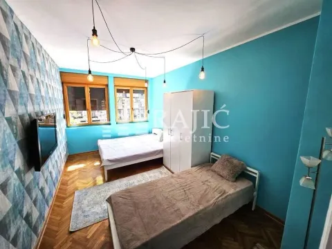 Furnished bedroom with two beds and blue walls. - image 10