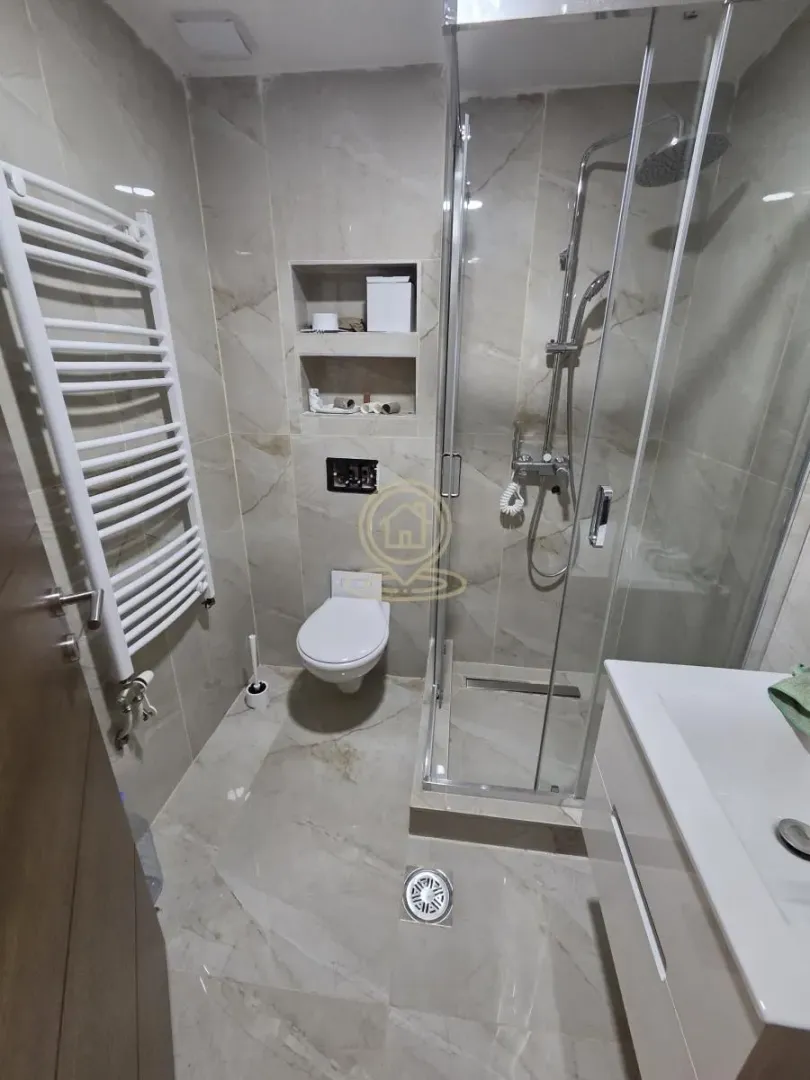 Moderno kupatilo sa tuš kabinom, WC šoljom i umivaonikom.