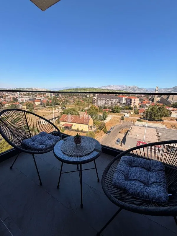 Namješten balkon sa garniturom za sjedenje i pogledom na grad.