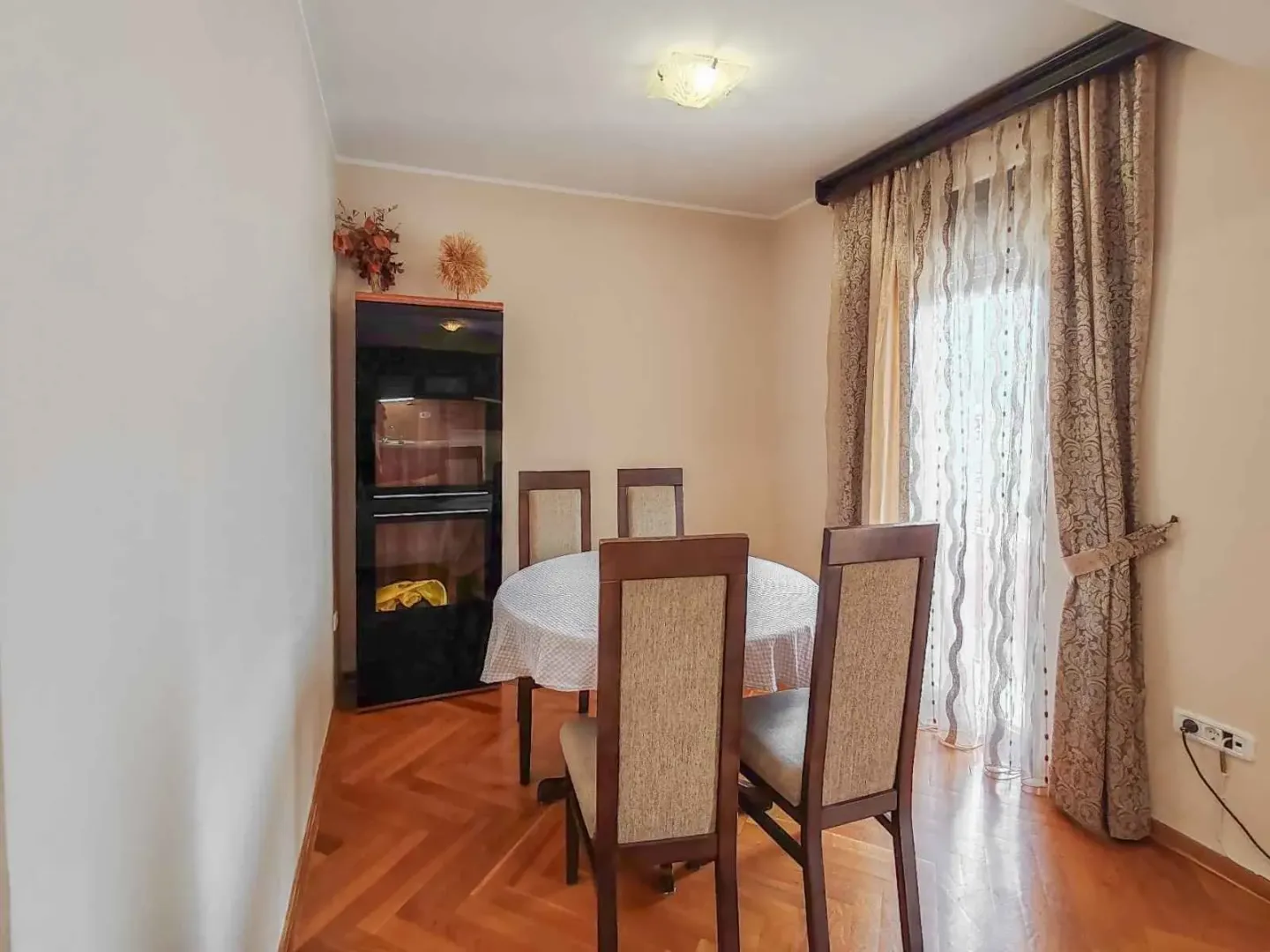 Dining area with a table, chairs, and parquet flooring.