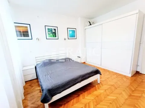 Bright bedroom with a double bed, white wardrobe, and parquet flooring. - image 6