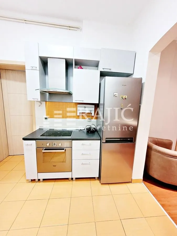 Small kitchen with white cabinets and a refrigerator.