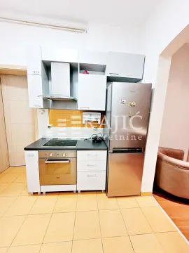 Small kitchen with white cabinets and a refrigerator. - image 13