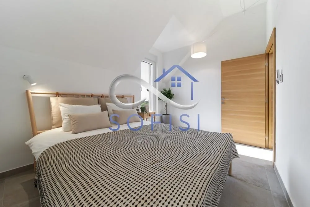Bright bedroom with a double bed and wooden doors.