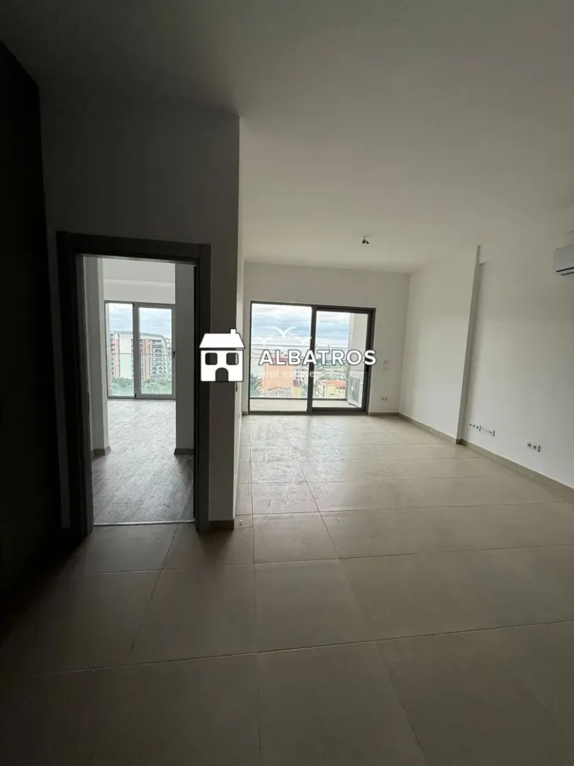 Prazna soba sa keramičkim pločicama i pogledom na terasu.