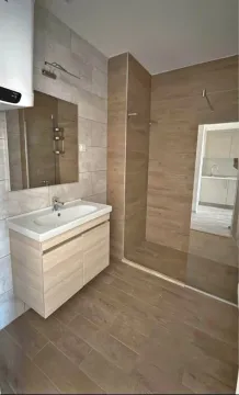 Savremeno opremljeno kupatilo sa tuš kabinom i umivaonikom. - image 5
