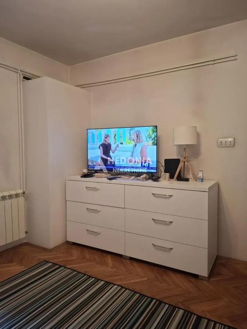 Bela komoda sa televizorom u sobi.