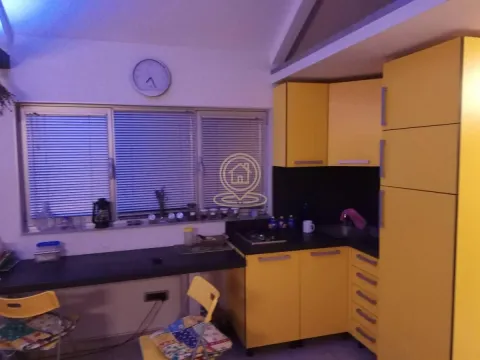 Kuhinja sa žutim elementima i prozorom sa roletnama. - image 8