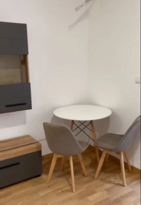 Mali okrugli trpezarijski sto sa dvije stolice u uglu prostorije.