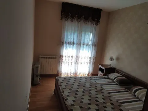 A simple bedroom featuring a double bed, nightstand, and a window. - image 10