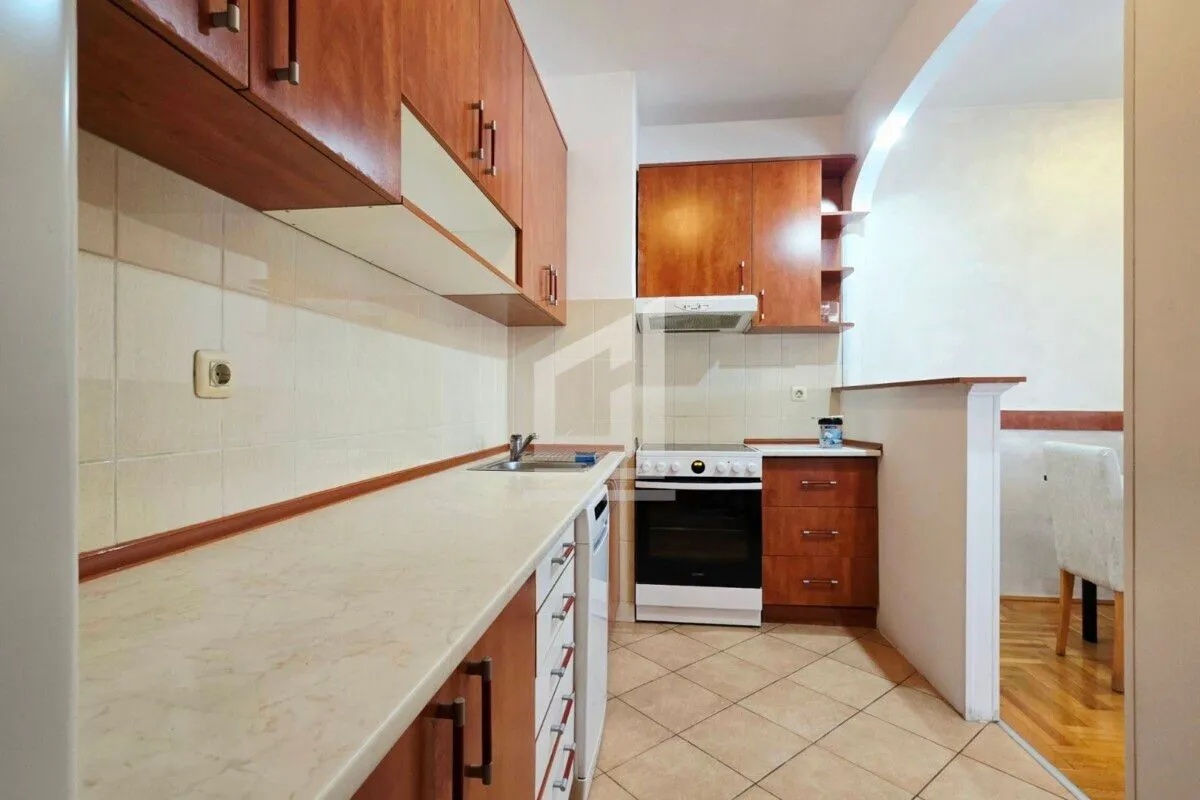 Small kitchen with wooden cabinets and a stove.