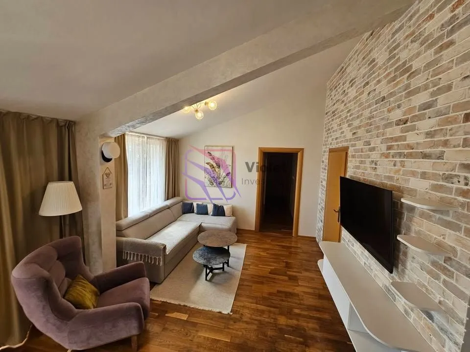 Living room with a sofa, TV, and a brick-clad wall.