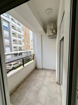 Empty and bright balcony with tiled flooring and a view of buildings. - image 9