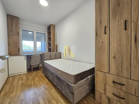 Manja spavaća soba sa krevetom, velikim drvenim ormanom, radnim stolom i prozorom. - image 16