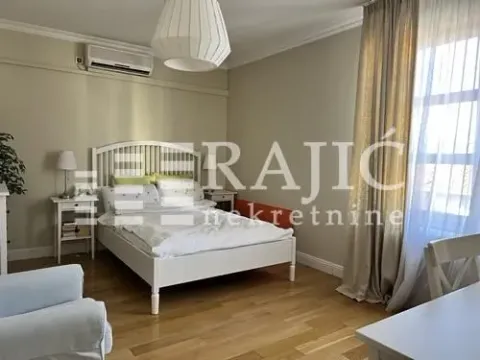 Uređena spavaća soba sa bračnim krevetom, noćnim stočićima i velikim prozorom. - image 2
