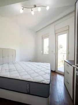 Svijetla spavaća soba sa bračnim krevetom, drvenim podom i izlazom na terasu. - image 7