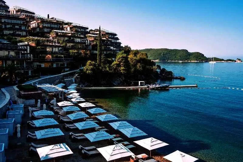 Pogled na plažu i obalu sa objektima u pozadini.