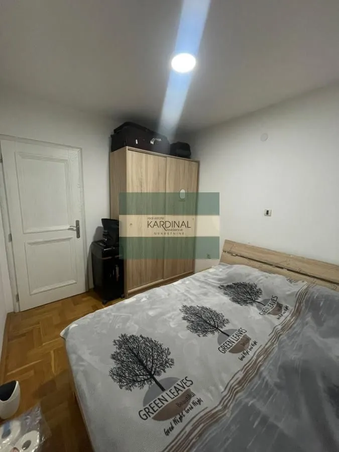 Furnished bedroom with a double bed and a wardrobe.