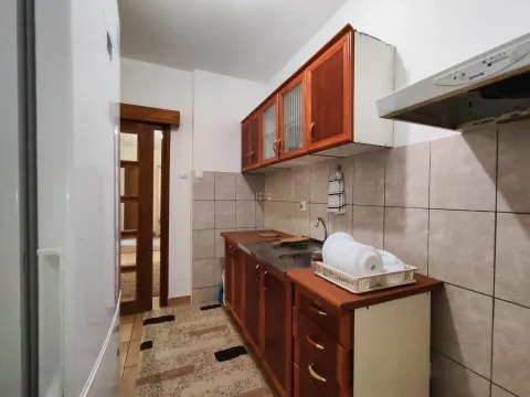 Jednostavna kuhinja sa drvenim elementima i svijetlim pločicama. - image 10
