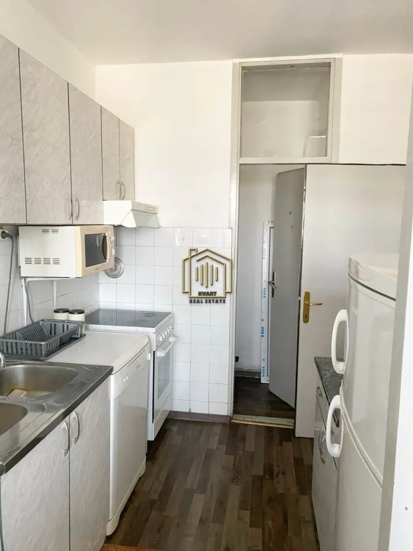 Small kitchen with white cabinets, a stove, and a refrigerator.