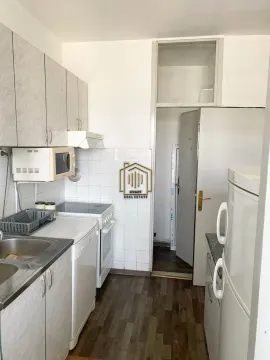 Small kitchen with white cabinets, a stove, and a refrigerator. - image 3